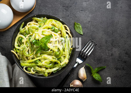 Les pâtes spaghetti à la courgette sur noir vue d'en haut. Banque D'Images