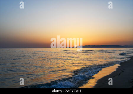 Coucher du soleil sur la mer de la plage de sable de Forte dei Marmi avec le soleil derrière la côte de la Versilia en été, la Versilia, Toscane, Italie Banque D'Images