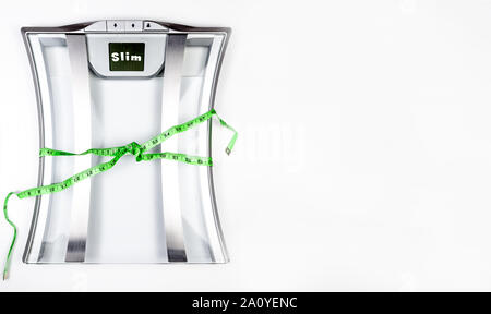 Balance de salle de bains électrique avec un ruban à mesurer à l'écran Slim montrant sur fond blanc. Concept de santé with copy space Banque D'Images