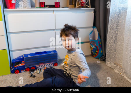 Portrait of a smiling, joli garçon de plusieurs années dans la chambre des enfants. Banque D'Images