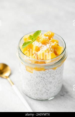 Semences Chia pudding à la mangue et le lait de coco dans un bocal en verre, isolé Banque D'Images