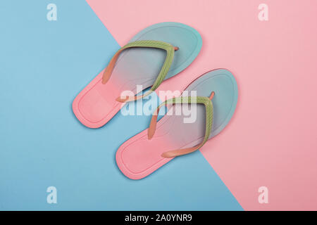Style flip-flops sur rose et bleu pastel arrière-plan, Vue de dessus. Le minimalisme d'été concept avec copie espace. Banque D'Images