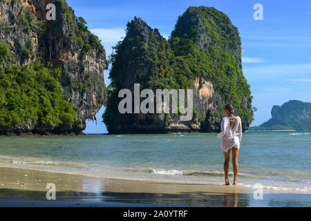 Séjour touristique en Thaïlande femme marche le long de la plage de Phra Nang Railay péninsule avec Ko Rang Nok en arrière-plan la mer d'Andaman Banque D'Images