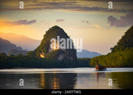 Bateau longtail thaïlandais à Krabi Thailande Falaises calcaires et Pak Nam River au coucher du soleil Banque D'Images