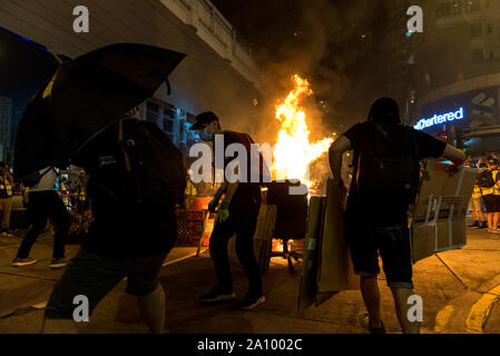 Hong Kong, Chine. 22 Sep, 2019. Les protestataires ajouter du combustible jusqu'au feu de la rue qui fait rage pendant la démonstration. Les manifestants se sont rassemblés en face de la station de Prince Edward, dénonçant les mesures prises par la police le 31 août et exigeant la libération des images de vidéosurveillance à partir de cette date. Les manifestants chahute et utilisé des stylos laser sur la police, mais ont rapidement été contraints de battre en retraite pendant une opération de dispersion. Malgré le retrait de la loi sur l'extradition, les manifestants ne sont pas satisfaits, exigent aujourd'hui les quatre autres 'demandes clés' de la part du gouvernement. Credit : SOPA/Alamy Images Limited Live News Banque D'Images