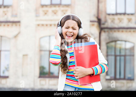 Cette chanson est une célébration de la joie. Happy little girl à chanter sa chanson préférée. Petit enfant jouit d'un morceau de l'école jouant dans des écouteurs. Nouvelle chanson et de nouvelles émotions. Banque D'Images