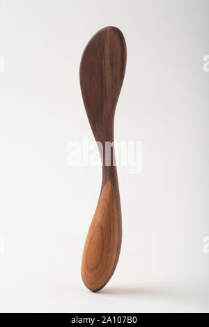 Un couteau à beurre en bois artisanal, fabriqué à partir de bois de cerisier et noyer. La courbe et la place de la poignée sont idéales dans la main. Banque D'Images