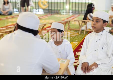 Enfants malais l'apprentissage de la langue à l'intérieur de la mosquée Masjid Sultan, Singapour Banque D'Images