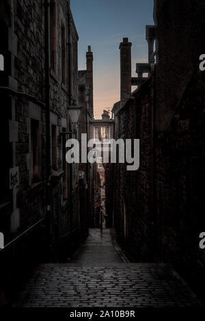 L'étroite ruelle, entourées de briques et cobblestone. Seulement illuminée avec faible lumière de l'aube. Concept de peur ou d'être seul et Banque D'Images