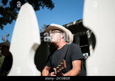 Un homme chante et joue de la guitare pour sa bande au cours de PorchFest à San Rafael, CA. Banque D'Images