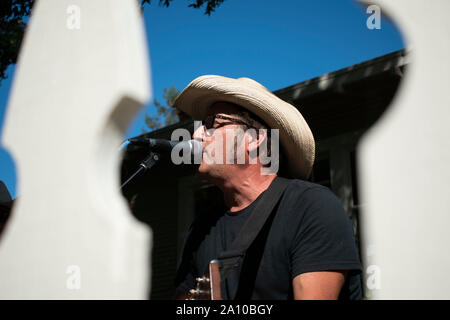 Un homme chante et joue de la guitare pour sa bande au cours de PorchFest à San Rafael, CA. Banque D'Images