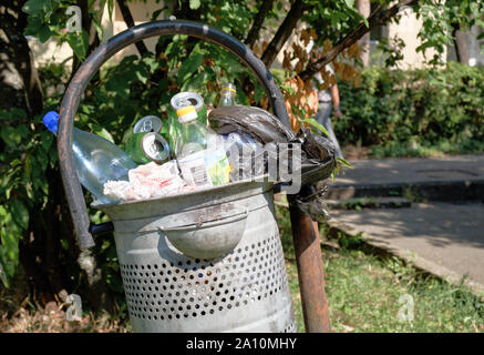 Parc métal poubelle débordant de boîtes de bière vides et les bouteilles en plastique Banque D'Images