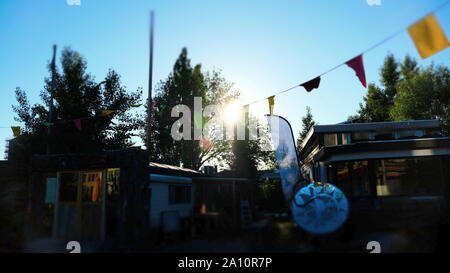 Houseboats Amsterdam sur les rives de la rivière Amstel avec fête colorée de drapeaux et de soleil dans les Pays-Bas Banque D'Images