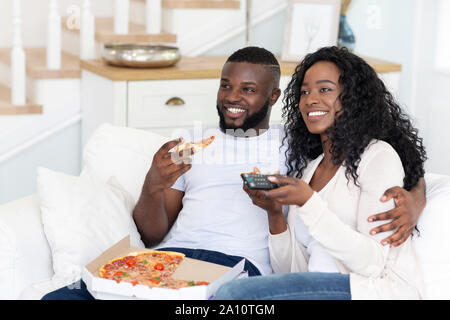 African American conjoints de manger des pizzas et regarder la télé à la maison Banque D'Images