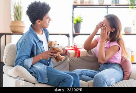 Surprise romantique. Petit ami adolescentes donnant actuel à sa copine avec plaisir Banque D'Images