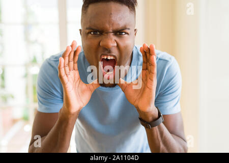 African American man hurlant de rage, cris enthousiastes avec la main sur la bouche Banque D'Images