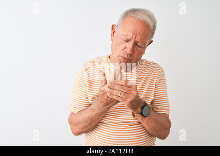 Hauts homme aux cheveux gris portant des T-shirt à rayures sur fond blanc isolé permanent souffrant de douleur sur les mains et les doigts, l'inflammation de l'arthrite Banque D'Images