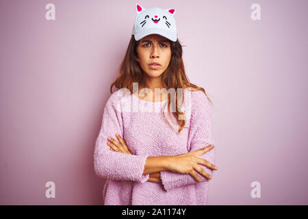 Belle Jeune femme portant chapeau chat drôle sur fond rose isolé permanent sceptique et nerveux, désapprouvant expression sur le visage avec un croisé Banque D'Images