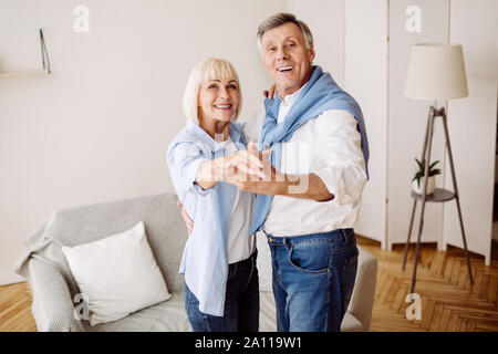 Vieux couple dansant ensemble dans la salle de séjour Banque D'Images