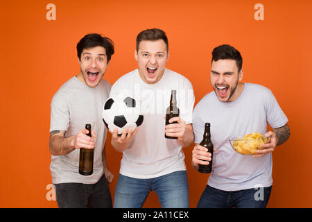 Heureux les amateurs de football regarder match avec de la bière et des collations Banque D'Images