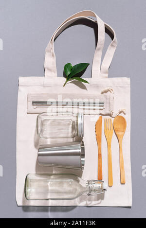Sacs en tissu, des pots de verre, métal des pailles, des couverts en bambou sur fond gris avec copie espace. Eco Friendly et réutilisation concept. Vue d'en haut. Mise à plat. A Zéro Banque D'Images