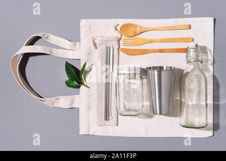 Sacs en tissu, des pots de verre, métal des pailles, des couverts en bambou sur fond gris avec copie espace. Eco Friendly et réutilisation concept. Vue d'en haut. Mise à plat. A Zéro Banque D'Images