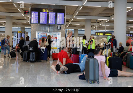 23 septembre 2019, l'Espagne, Palma : Le jour de l'insolvabilité du groupe britannique Thomas Cook, les passagers sont debout à l'aéroport de Palma de Majorque à parler aux employés de l'aviation britannique des organisateurs de voyages (Licence ATOL) qui prennent soin de le voyage de retour des voyageurs touchés par l'insolvabilité de Thomas Cook et de ses filiales. Les efforts pour sauver le groupe de tourisme Thomas Cook britannique ont échoué. La deuxième plus grande compagnie de voyage en Europe a annoncé qu'une pétition d'insolvabilité correspondant avait déjà été déposé à la cour. Photo : Clara Margais/dpa Banque D'Images