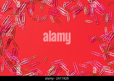 Châssis de trombones multicolores sur fond rouge. Retour à l'école. Office de tourisme, d'affaires, les formalités administratives, de l'éducation concept. Bannière. Banque D'Images