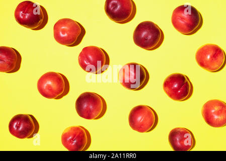 Les nectarines sur fond jaune. Cadre fait de fruits frais. Mise à plat, vue du dessus, copiez l'espace. Régime végétarien et végétalien. Banque D'Images