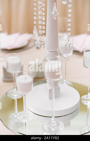 Peu de verre élégant dans lequel chandeliers bougies en vrac blanc Banque D'Images