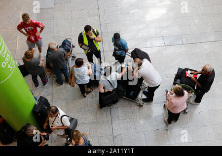 23 septembre 2019, l'Espagne, Palma : Le jour de l'insolvabilité du groupe britannique Thomas Cook, les passagers sont debout à l'aéroport de Palma de Majorque à parler à un employé de l'aviation britannique des organisateurs de voyages (licence) de l'atol, qui prennent soin de le voyage de retour des voyageurs touchés par l'insolvabilité de Thomas Cook et de ses filiales. Les efforts pour sauver le groupe de tourisme Thomas Cook britannique ont échoué. La deuxième plus grande compagnie de voyage en Europe a annoncé qu'une pétition d'insolvabilité correspondant avait déjà été déposé à la cour. Photo : Clara Margais/dpa Banque D'Images