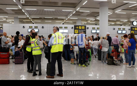 Palma, Espagne. Sep 23, 2019. Le jour de l'insolvabilité du groupe Thomas Cook voyages britanniques à l'aéroport de Palma de Majorque, les passagers se tenir derrière les employés du gouvernement britannique qui sont responsables pour le voyage de retour des voyageurs touchés par l'insolvabilité de Thomas Cook et de ses filiales. Les efforts pour sauver le groupe de tourisme Thomas Cook britannique ont échoué. La deuxième plus grande compagnie de voyage en Europe a annoncé qu'une pétition d'insolvabilité correspondant avait déjà été déposé à la cour. Credit : Clara Margais/dpa/Alamy Live News Banque D'Images