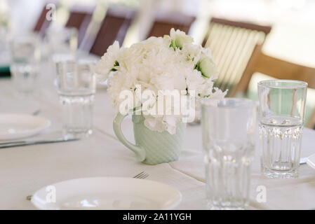 Un bouquet de roses doux blanc mug dans un petit vase de style. Banque D'Images