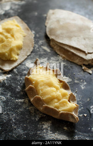 Le carélien traditionnel pasties avec pommes de terre avant four Banque D'Images