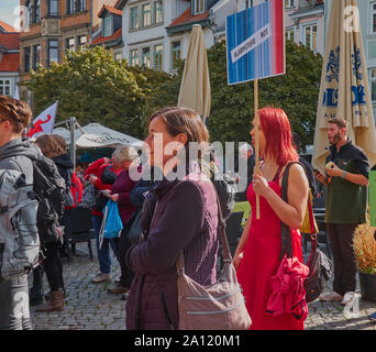 Braunschweig, Allemagne, le 20 septembre., 2019 : Jeune femme en robe rouge vif et aux cheveux rouges holding up un bouclier Banque D'Images