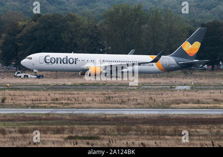 23 septembre 2019, Hessen, Frankfurt/Main : un Boeing 767-300 de la compagnie aérienne Condor est remorqué par un remorqueur à l'aéroport de Francfort. Les efforts pour sauver le groupe de tourisme Thomas Cook britannique ont échoué. Photo : Silas Stein/dpa Banque D'Images