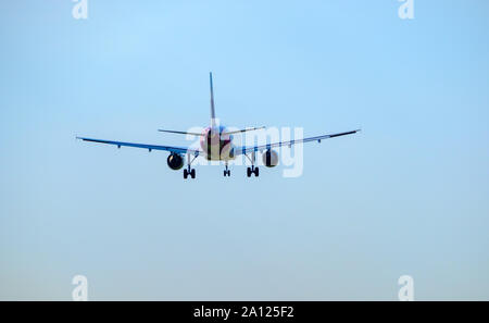 Vol d'un avion de passagers en bleu ciel, vue arrière Banque D'Images