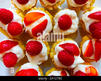 Fresh fait framboise et tartelettes aux fraises sur une plaque blanche Banque D'Images