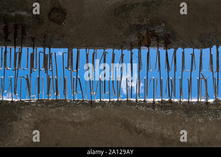 Sous le pont. Trou avec un ciel bleu. Résumé Contexte la construction. Les tiges métalliques dans le béton. Ancien objet en reconstruction. Banque D'Images