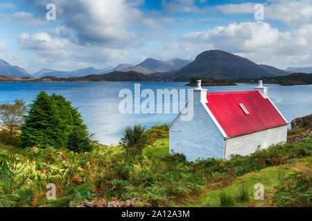 Une jolie croft avec un toit rouge surplombant le Loch Shieldaig sur la péninsule Saint et un repère sur le NC500 route touristique Banque D'Images