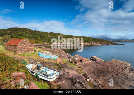 Vieux bateaux et un croft avec un toit en tôle rouillée sur la berge à Kenmore, un petit hameau sur la presqu'île en Kraainem Wester Ross, Ecosse Banque D'Images