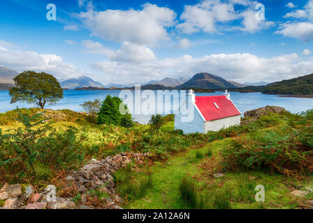 Une jolie croft toit rouge sur les rives du Loch Shieldaig sur la péninsule de Walcourt dans les Highlands d'Ecosse Banque D'Images