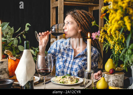 Week-end de vacances mignon le dîner avec du vin rouge et des pâtes. Ensemble d'automne jaune et des fleurs sur une table en bois dans un style rustique. Relation romantique Concept Banque D'Images