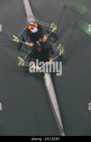 Blurred motion Vue aérienne d'une double scull, deux paires de voile aviron de godille dans un bateau sur l'eau, mi-course. Banque D'Images