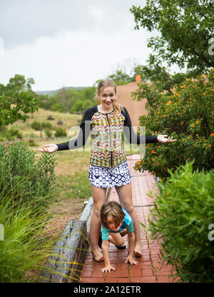 Garçon de 5 ans et sa soeur de 13 ans la danse de la pluie. Banque D'Images