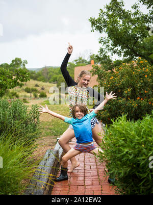 Garçon de 5 ans et sa soeur de 13 ans la danse de la pluie. Banque D'Images