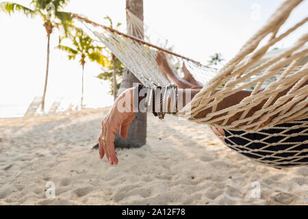 Close up of woman's arm et bracelets, de repos en hamac Banque D'Images