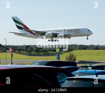 Un Airbus A380 Emirates Airlines à l'atterrissage à l'aéroport de Birmingham vu l'ensemble des voitures en stationnement, UK (A6-EUZ) Banque D'Images