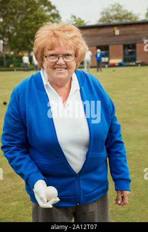 Un portrait of a senior woman smiling at un boulodrome, tenant un jeu de boules lyonnaises. Banque D'Images