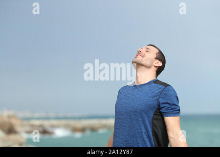 Happy runner, respirant profondément l'air frais sur la plage avant le sport Banque D'Images